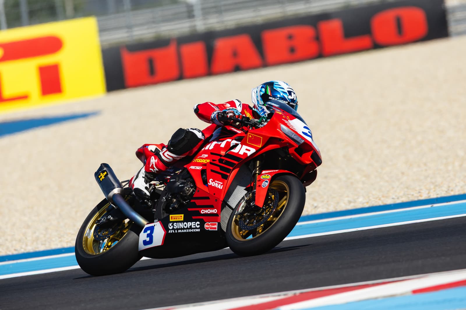 QJMOTOR racing motorcycle and rider leaning through a track corner